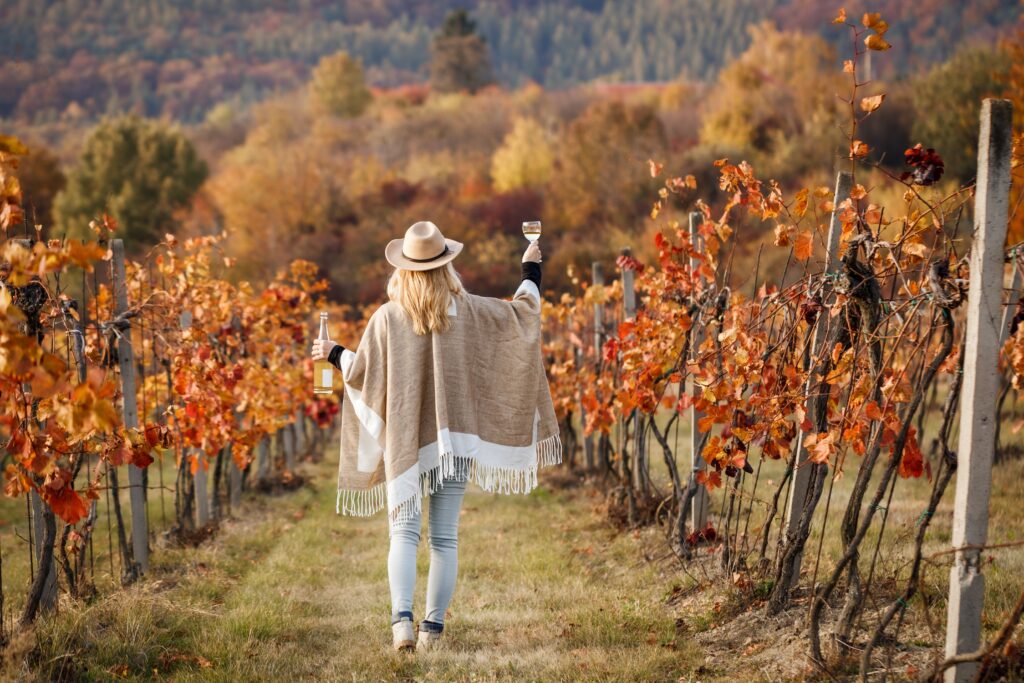 Woman,With,Poncho,And,Hat,Enjoying,White,Wine,In,Her