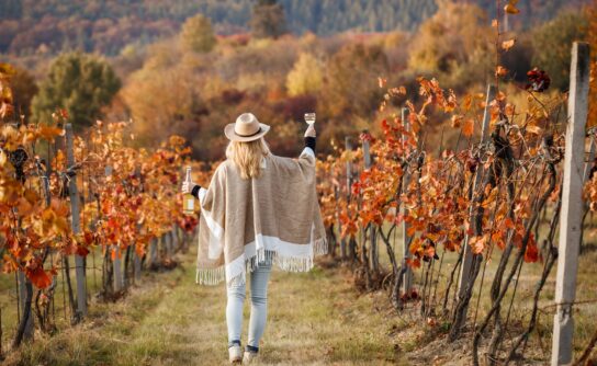 Woman,With,Poncho,And,Hat,Enjoying,White,Wine,In,Her